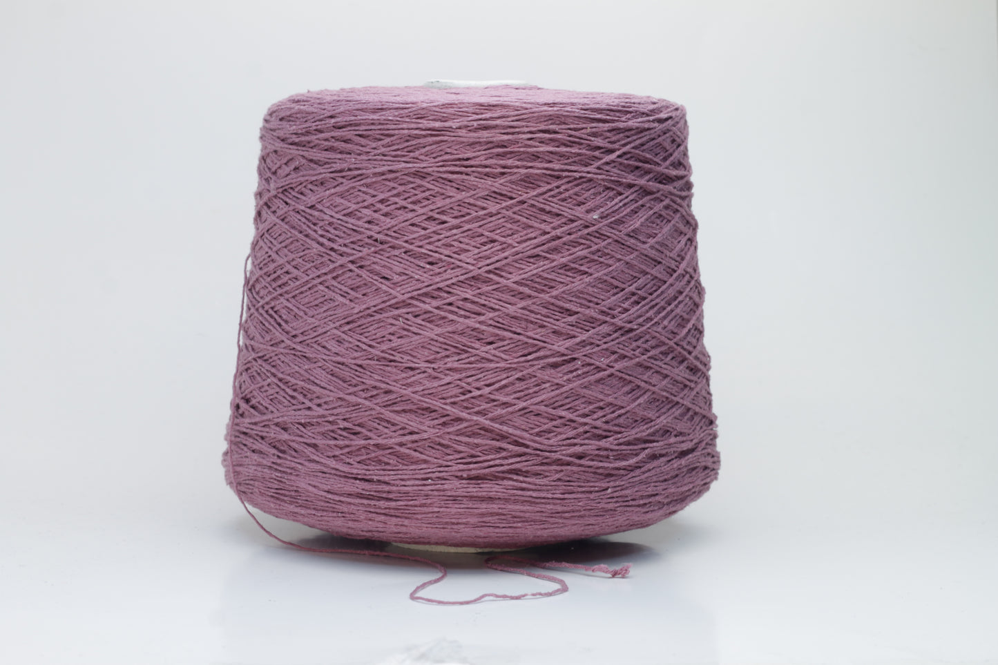 Close-up image of the burgundy silk bourette yarn, showcasing a dense ply twist and subtle sheen. The yarn appears incredibly soft and fluffy with rich color depth.