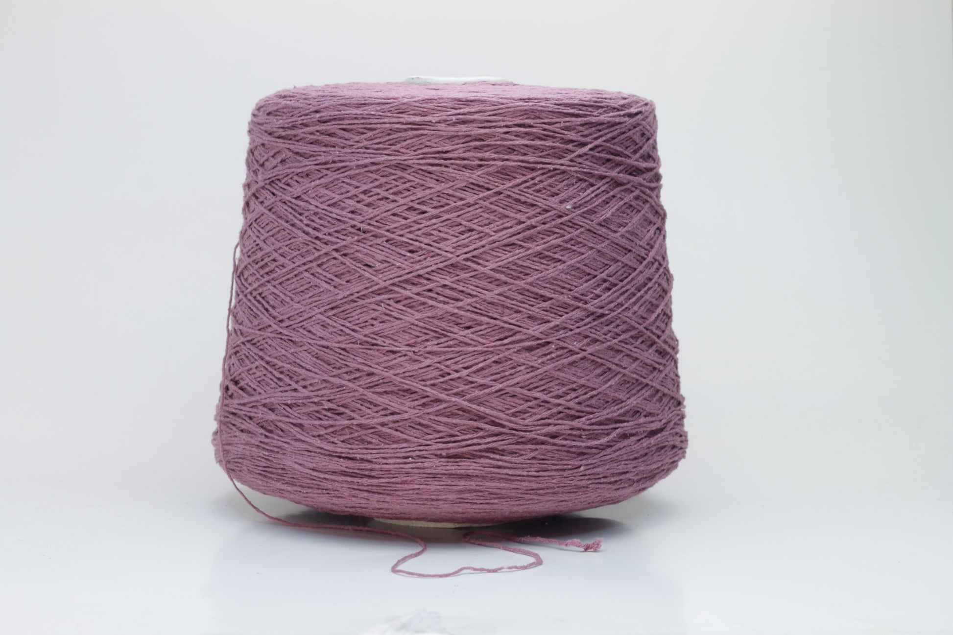 Close-up image of the burgundy silk bourette yarn, showcasing a dense ply twist and subtle sheen. The yarn appears incredibly soft and fluffy with rich color depth.