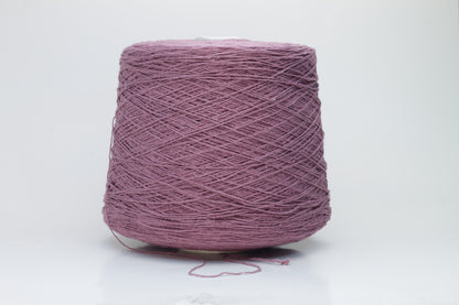 Close-up image of the burgundy silk bourette yarn, showcasing a dense ply twist and subtle sheen. The yarn appears incredibly soft and fluffy with rich color depth.