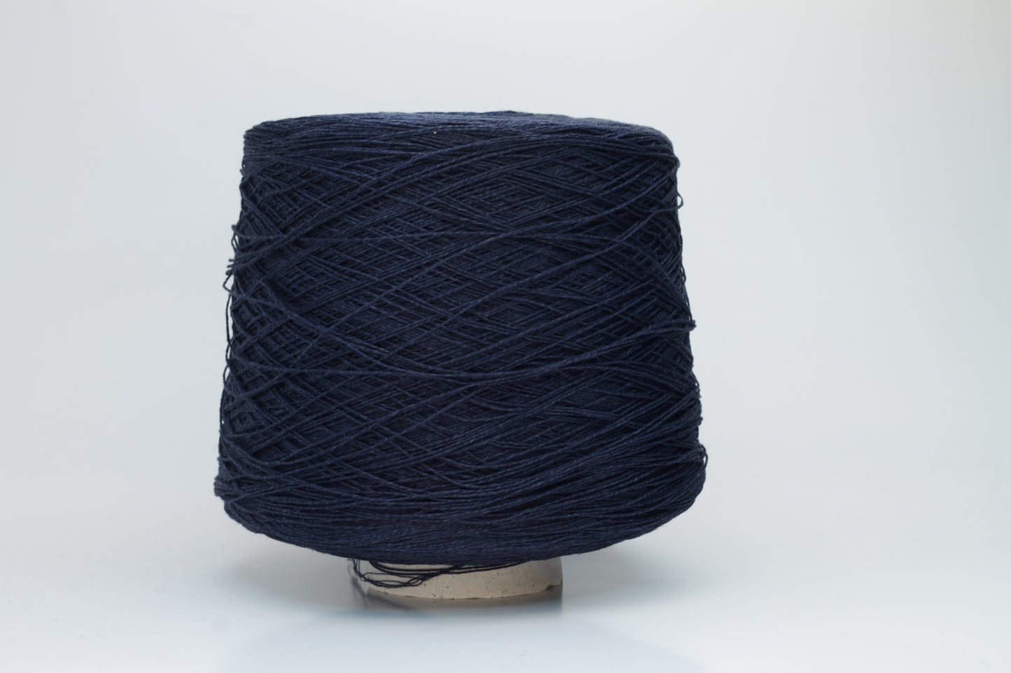 Close-up of pristine Navy linen and viscose blend yarn, softly twisted with a subtle sheen, showcasing its fine, smooth texture.