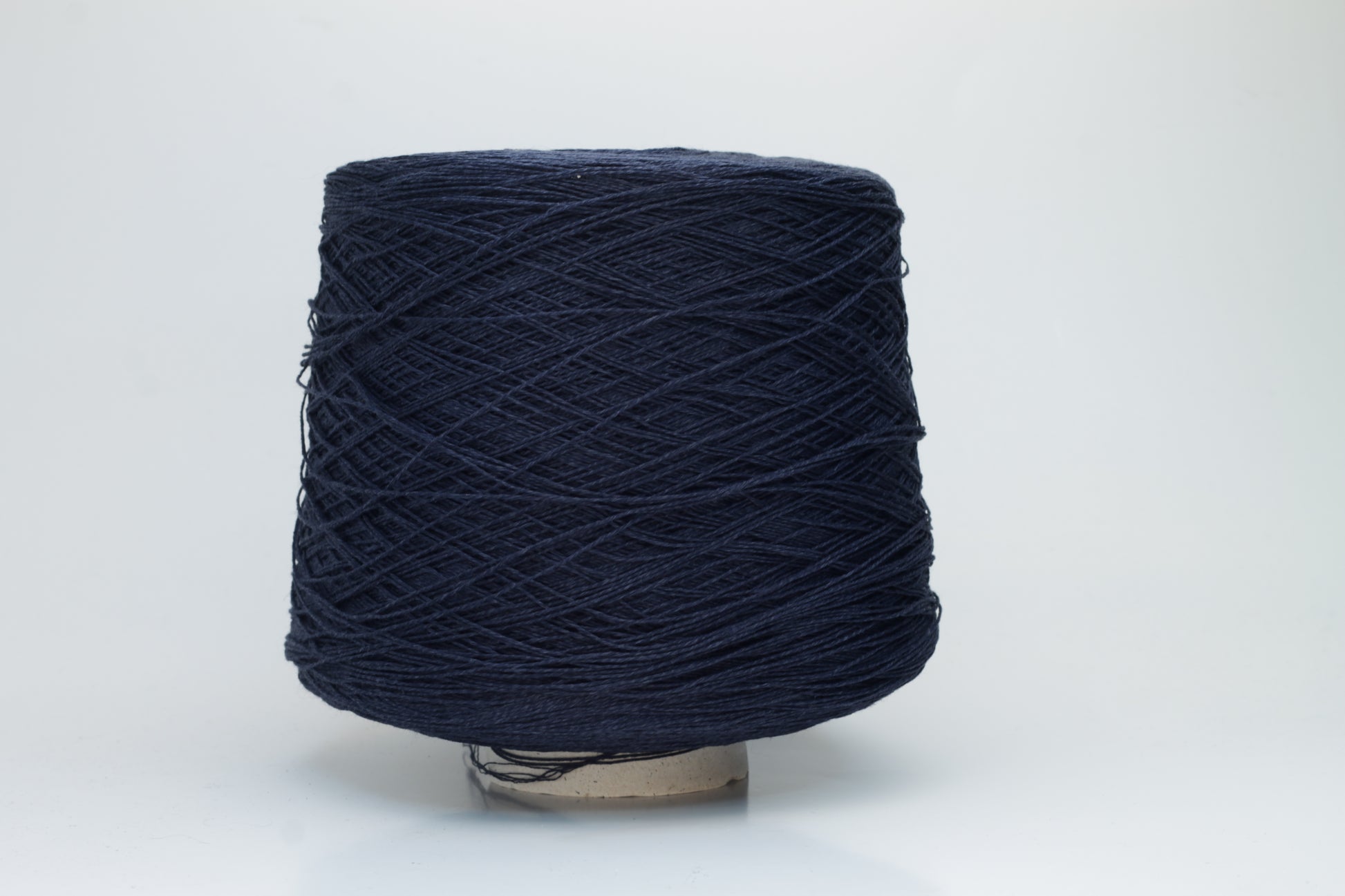 Close-up of pristine Navy linen and viscose blend yarn, softly twisted with a subtle sheen, showcasing its fine, smooth texture.