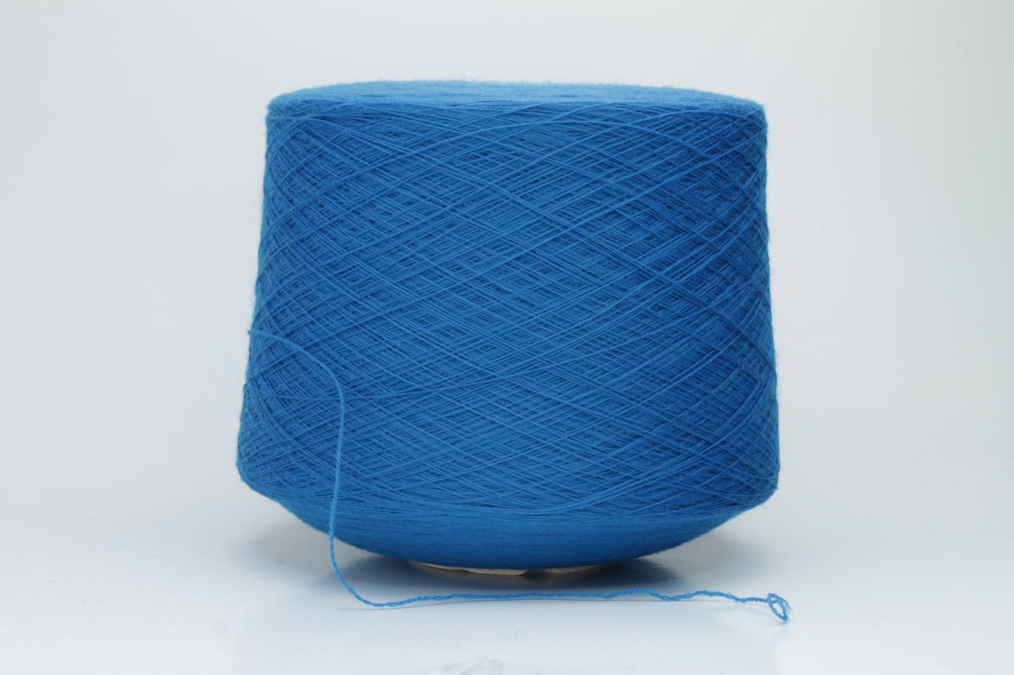 Close-up view of Zegna Baruffa Merino 100% Cashwool yarn in a deep blue hue, showcasing the twisted ply structure and subtle sheen with a fluffy texture.