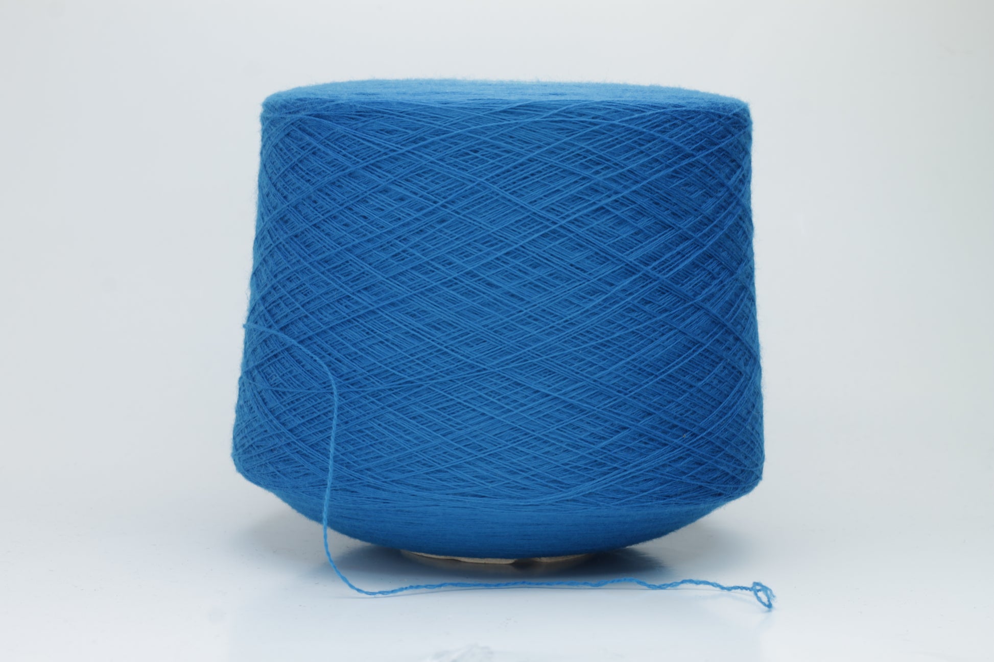 Close-up view of Zegna Baruffa Merino 100% Cashwool yarn in a deep blue hue, showcasing the twisted ply structure and subtle sheen with a fluffy texture.