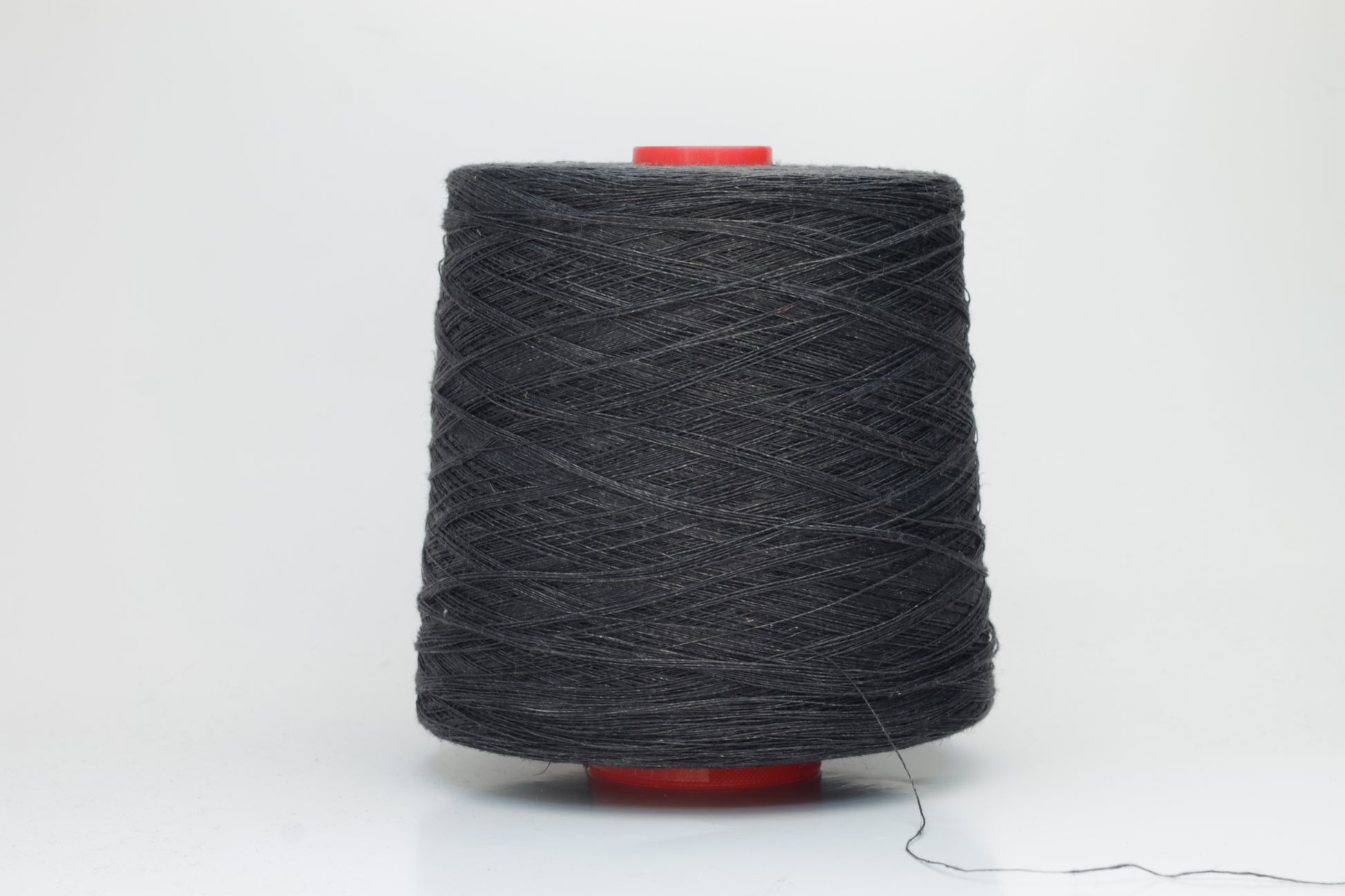 Fine, single-ply linen yarn in a rich Charcoal Black. Reveals a crisp texture and subtle natural sheen, typical of pure linen fiber.