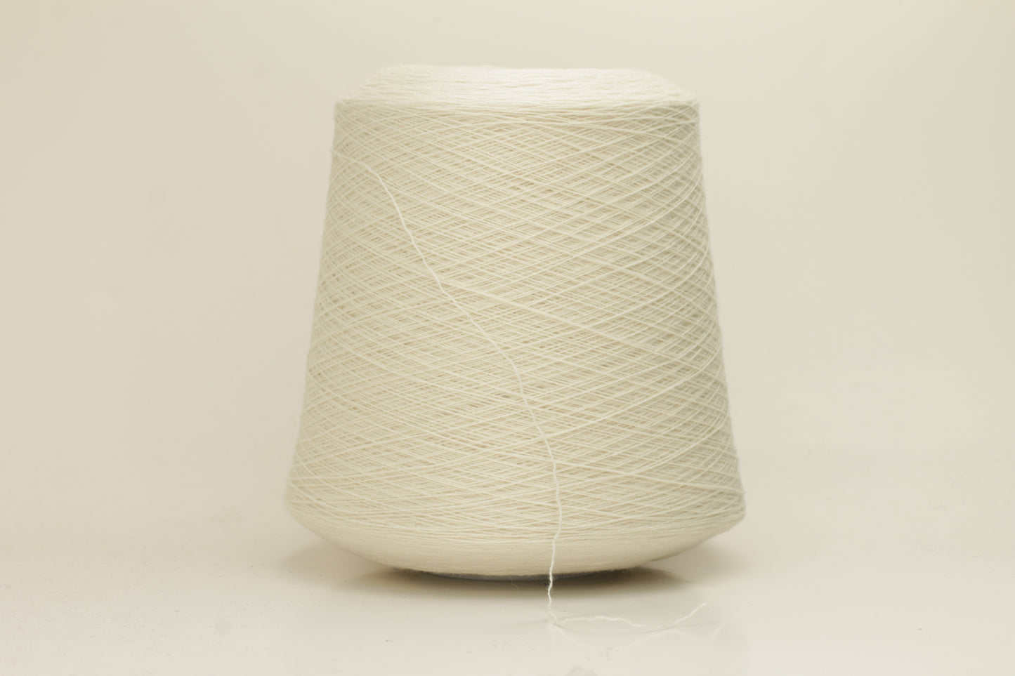 Close-up of a skein of pristine Ice White 100% cashmere yarn, showcasing its fine, evenly plied two-ply structure and delicate, soft halo.
