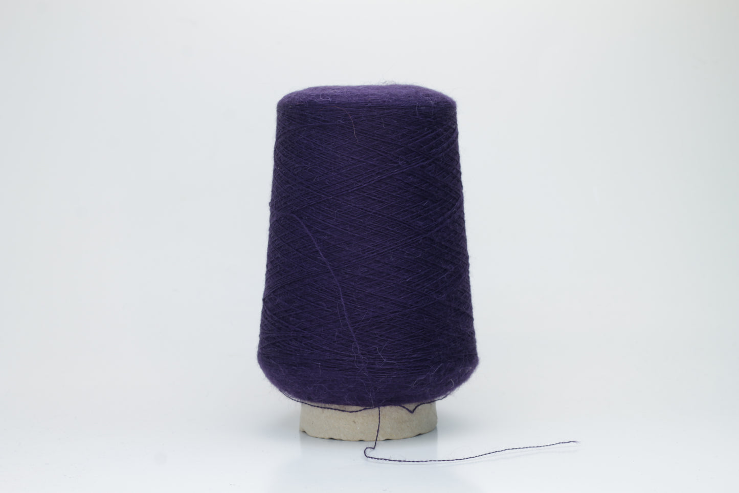 Rich purple 2-ply Alpaca Merino yarn, softly twisted with a gentle halo and subtle sheen, showcasing its deep, luxurious color saturation.
