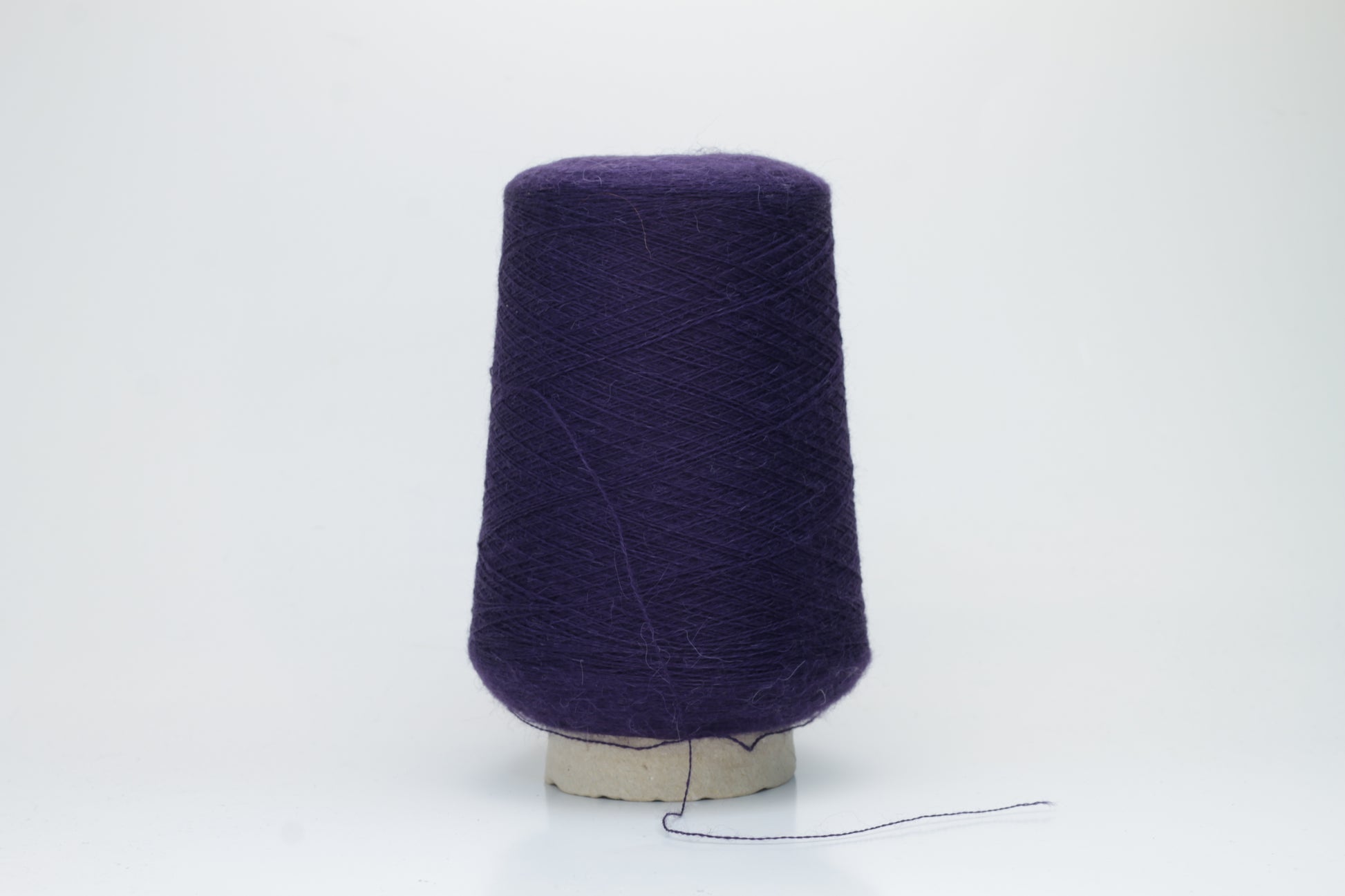 Rich purple 2-ply Alpaca Merino yarn, softly twisted with a gentle halo and subtle sheen, showcasing its deep, luxurious color saturation.