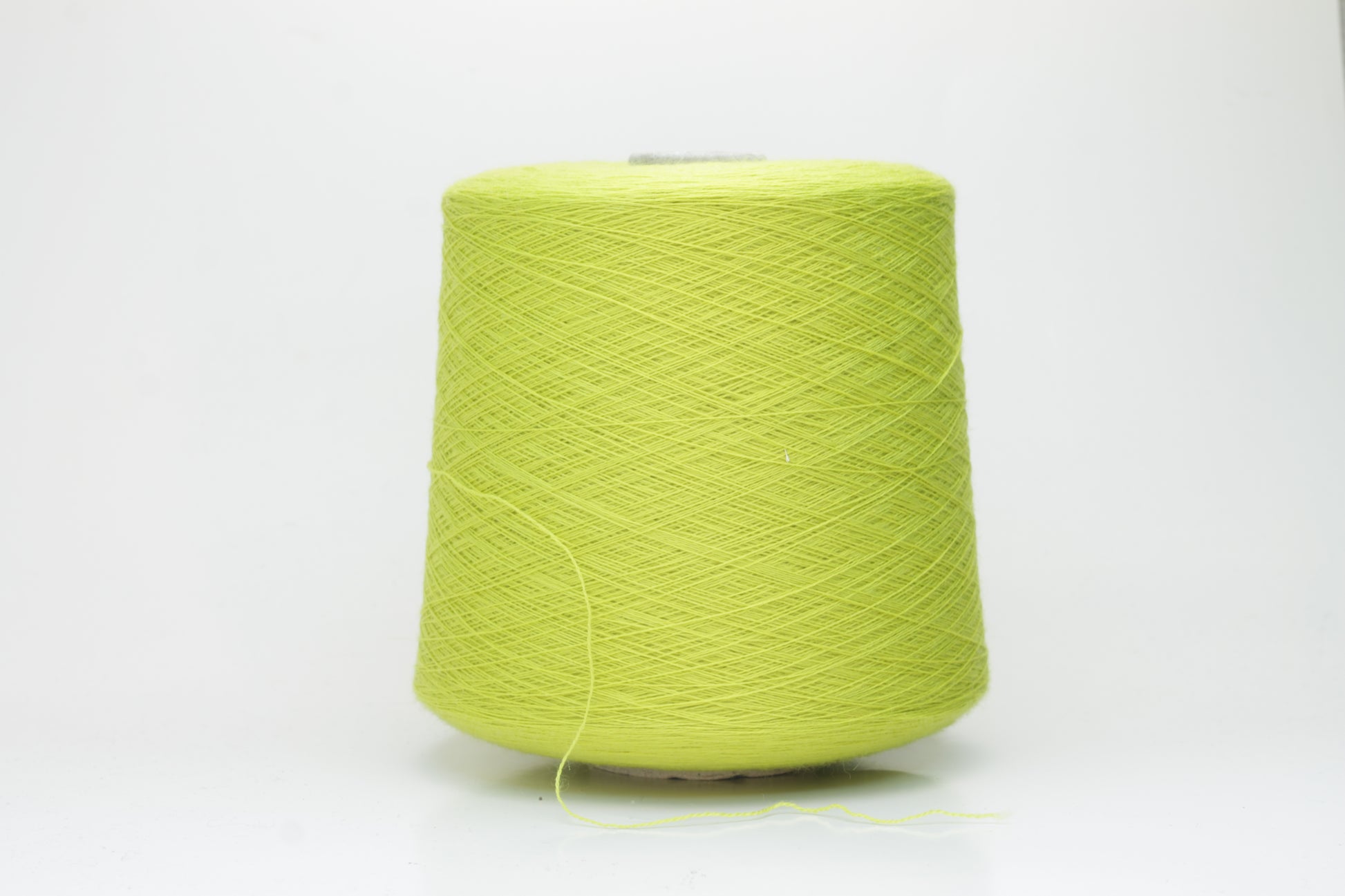 Close-up of luxurious Lime Merino wool yarn, two-ply twist with a soft, subtle sheen, and fine, consistent thread structure.