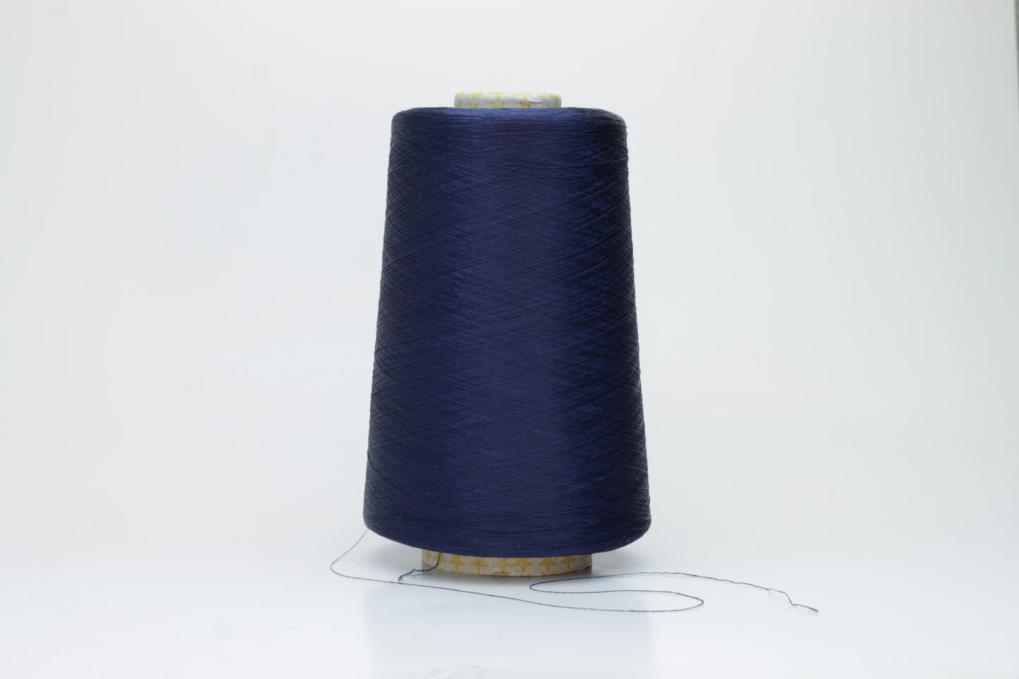 Close-up of finely spun navy blue silk yarn, gently twisted, displaying a subtle, elegant sheen. Smooth, lustrous fibers reflect light softly, hinting at fluid drape and rich color depth.