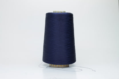 Close-up of finely spun navy blue silk yarn, gently twisted, displaying a subtle, elegant sheen. Smooth, lustrous fibers reflect light softly, hinting at fluid drape and rich color depth.
