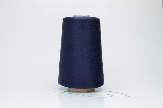 Close-up of finely spun navy blue silk yarn, gently twisted, displaying a subtle, elegant sheen. Smooth, lustrous fibers reflect light softly, hinting at fluid drape and rich color depth.