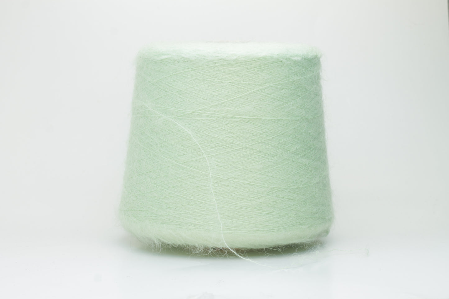 Close-up view of Light Green SuperKidMohair yarn showing a dense, fluffy pile structure and subtle sheen. The yarn has a uniform ply twist with a rich color depth.