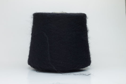 Close-up shot of the Black SuperKidMohair yarn, showcasing its dense ply twist and subtle sheen. The fibers appear fluffy and richly colored, creating a luxurious tactile impression.