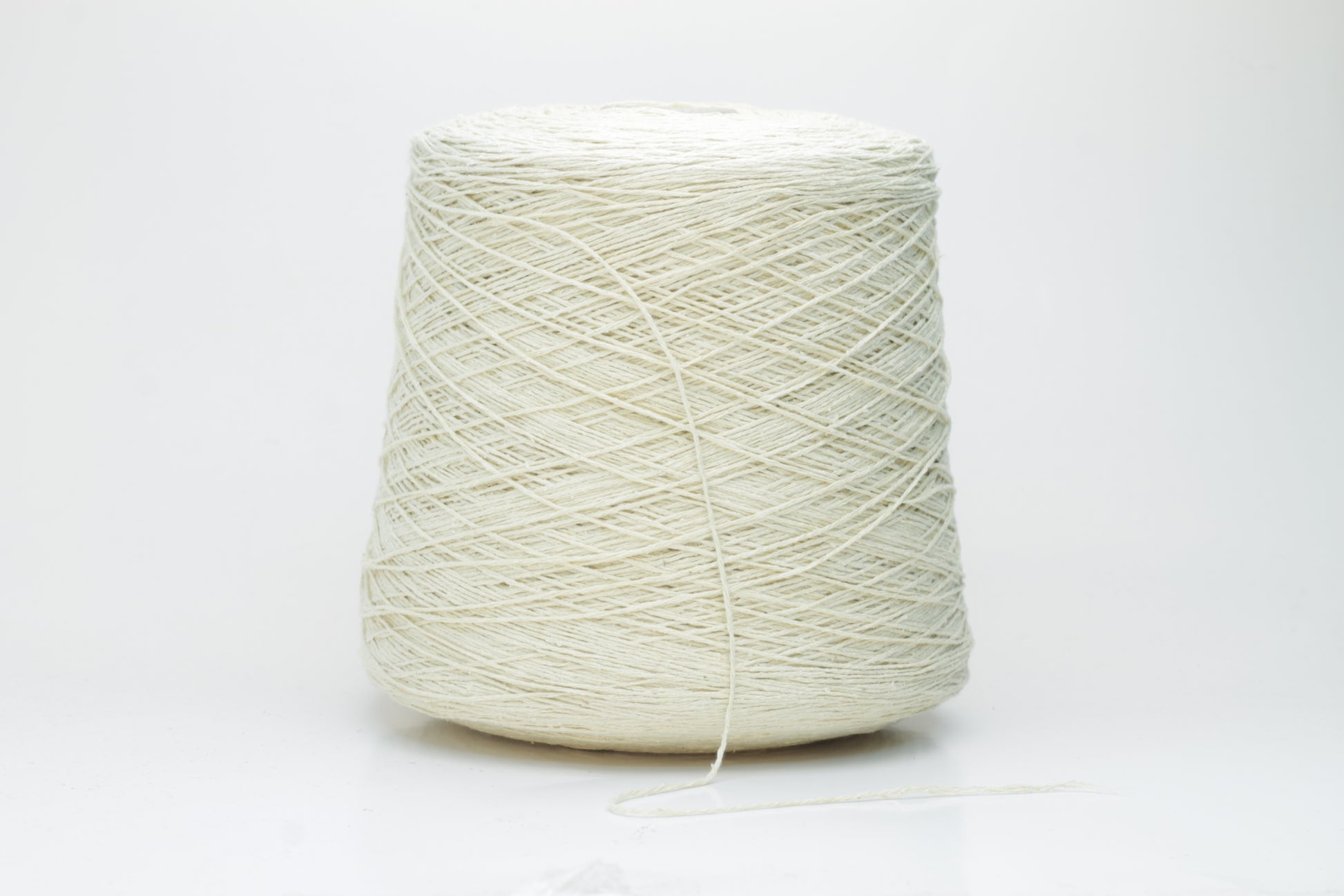 Close-up of creamy 'Giallino' Silk Bourette yarn, showcasing its incredibly fine ply twist and subtle sheen. The yarn has a smooth, almost liquid texture with abundant fluffiness.