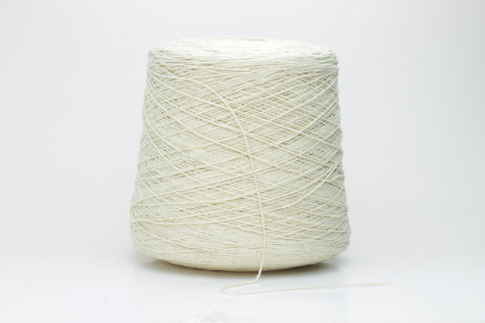 Close-up of creamy 'Giallino' Silk Bourette yarn, showcasing its incredibly fine ply twist and subtle sheen. The yarn has a smooth, almost liquid texture with abundant fluffiness.