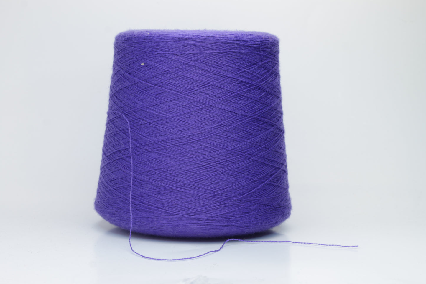 Close-up shot of a vibrant blue Zegna Baruffa Merino yarn skein, displaying its fine ply twist and soft, fluffy texture with subtle sheen.