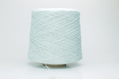Close-up of a skein of unspun, single-ply bourette silk yarn. It has a natural, slightly textured, slubbed surface with a soft matte sheen in a serene acqua blue-green hue.