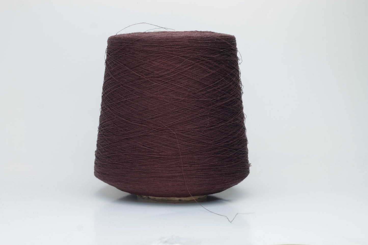 Close-up of a tightly twisted, fine-gauge yarn in a deep, warm earthy brown color, showing a subtle natural sheen from the linen fibers.