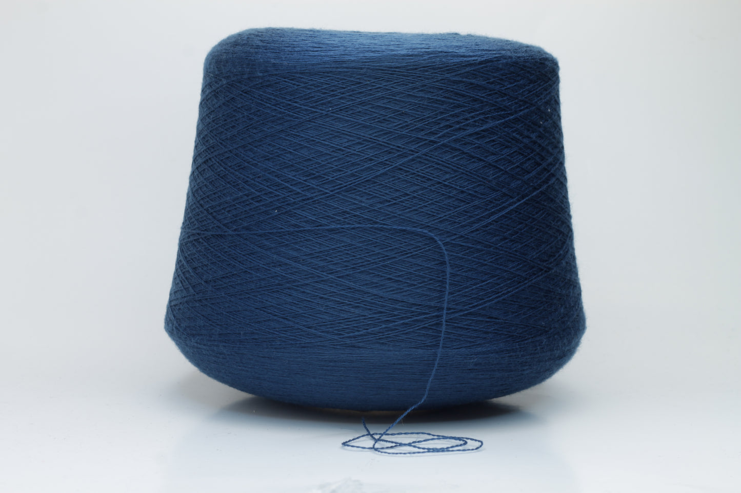 Close-up view of ZEGNA BARUFFA Merino 100% Cashwool, Nm 2/30, Color Blue. The yarn showcases a tight, even ply twist with a dense thread structure and subtle sheen reflecting the deep blue color, presenting a fluffy and inviting texture.