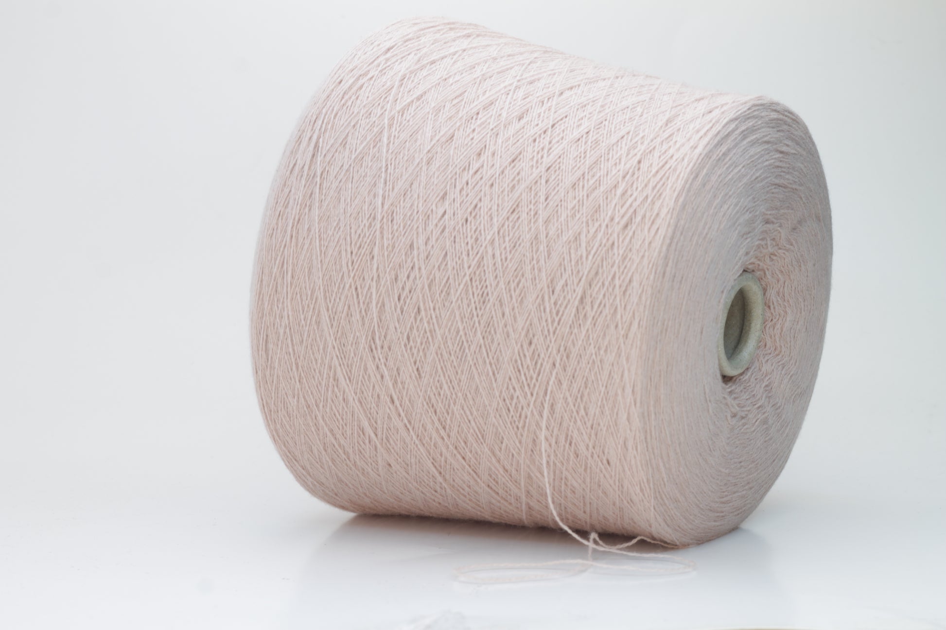 Soft, slightly fuzzy two-ply cashmere yarn in a muted, warm dusty rose color with a subtle sheen, loosely wound in a skein.