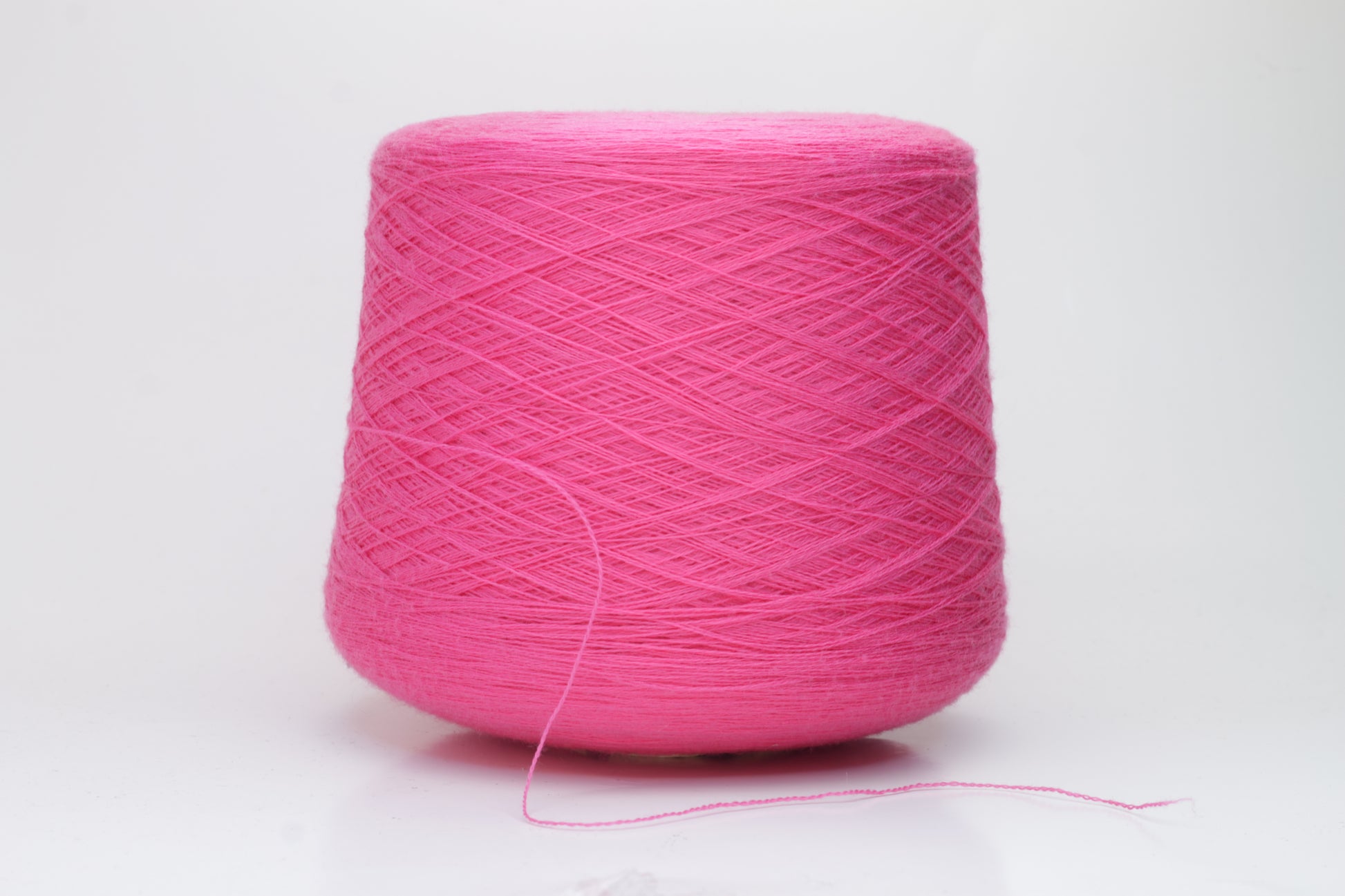Close-up view of vibrant hot pink Zegna Baruffa Merino Cashwool yarn, showcasing its smooth, twisted ply structure and rich color depth.
