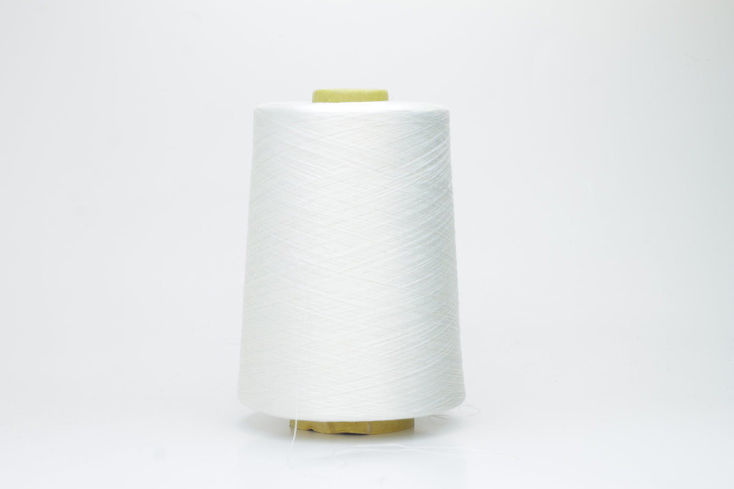 A close-up of premium 100% silk yarn, tightly plied, displaying a smooth, lustrous surface and a warm, creamy latte beige color.