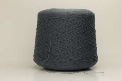 Close-up of a skein of dark, stormy blue-grey cashmere yarn with a subtle sheen. The fine, two-ply twist is visible, creating a smooth, incredibly soft thread structure that suggests luxurious warmth.