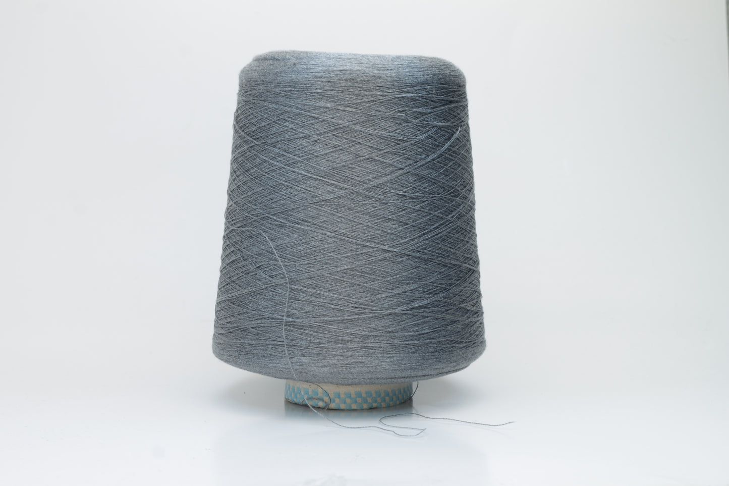 Close-up of a meticulously twisted two-ply 100% silk yarn, revealing a subtle, sophisticated medium gray hue with a natural, elegant sheen.