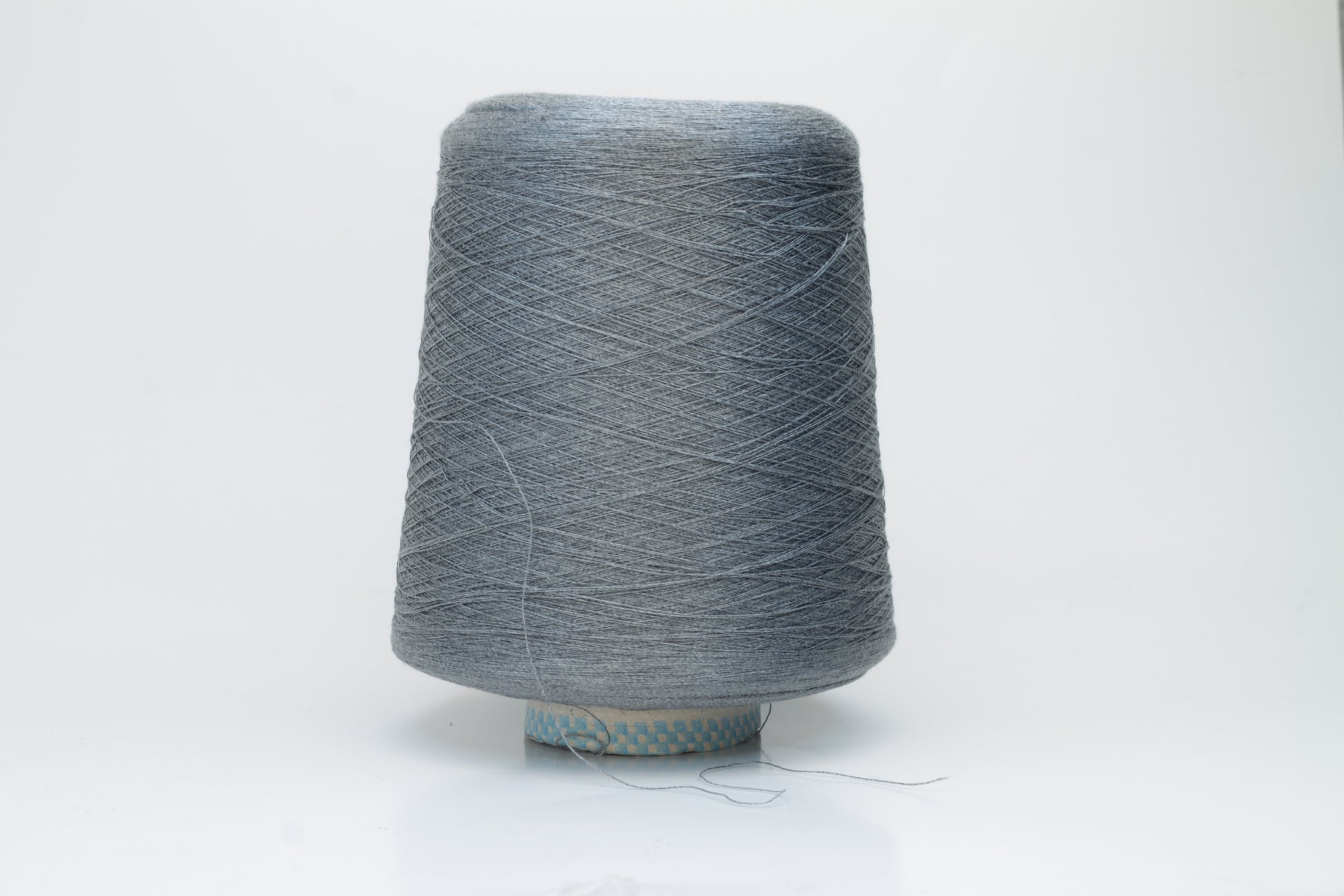 Close-up of a meticulously twisted two-ply 100% silk yarn, revealing a subtle, sophisticated medium gray hue with a natural, elegant sheen.