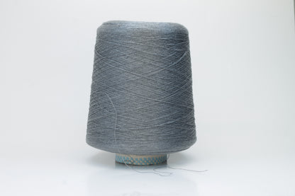 Close-up of a meticulously twisted two-ply 100% silk yarn, revealing a subtle, sophisticated medium gray hue with a natural, elegant sheen.