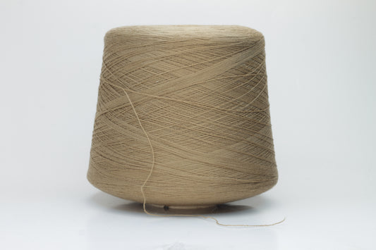 Close-up shot of a cone of creamy camel colored 100% merino yarn, showcasing the fine ply twist and subtle sheen of the fibers.