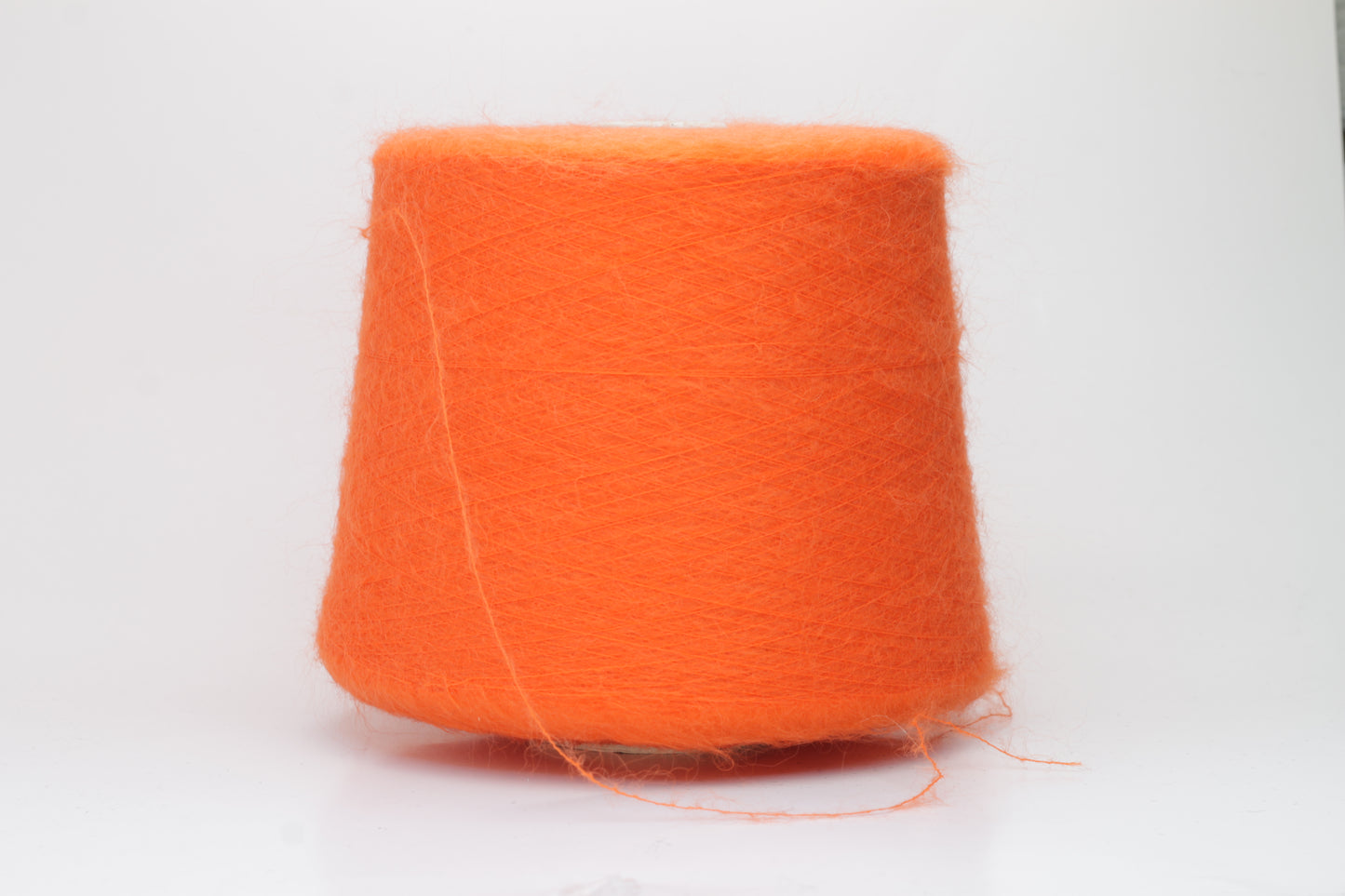 Close-up shot of vibrant orange SuperKidMohair yarn, displaying a tight ply twist and a rich, fluffy texture with noticeable sheen.