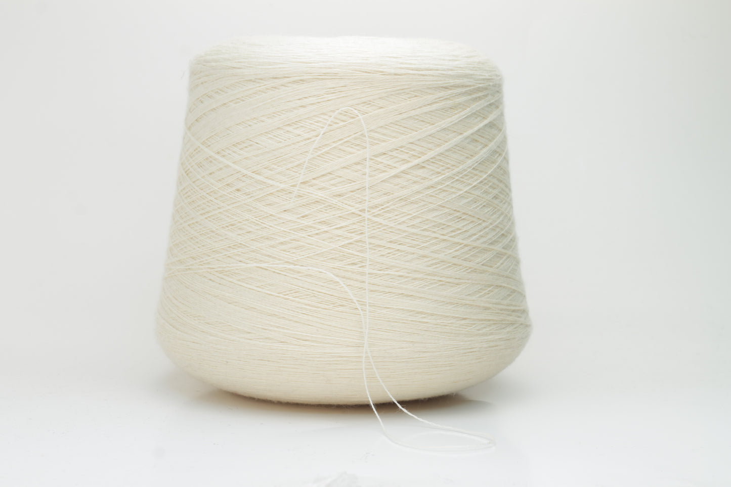 Close-up view of Zegna Baruffa Merino 100% Cashwool yarn in Milk Color. The yarn features a tight, even ply twist with visible thread structure, creating a subtle sheen and fluffy texture – perfect for intricate knitting designs.