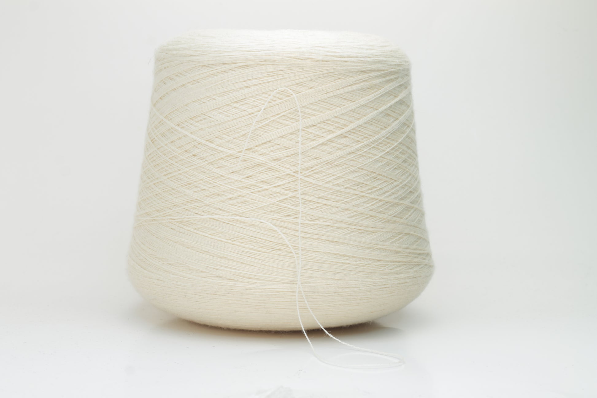 Close-up view of Zegna Baruffa Merino 100% Cashwool yarn in Milk Color. The yarn features a tight, even ply twist with visible thread structure, creating a subtle sheen and fluffy texture – perfect for intricate knitting designs.