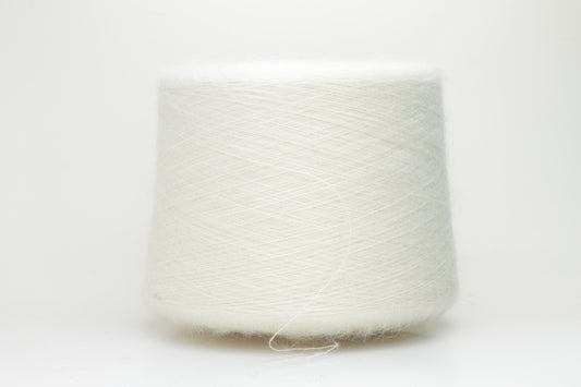 Close-up of pristine white SuperKidMohair Silk yarn, revealing its delicate halo, subtle sheen, and fine, even ply twist.