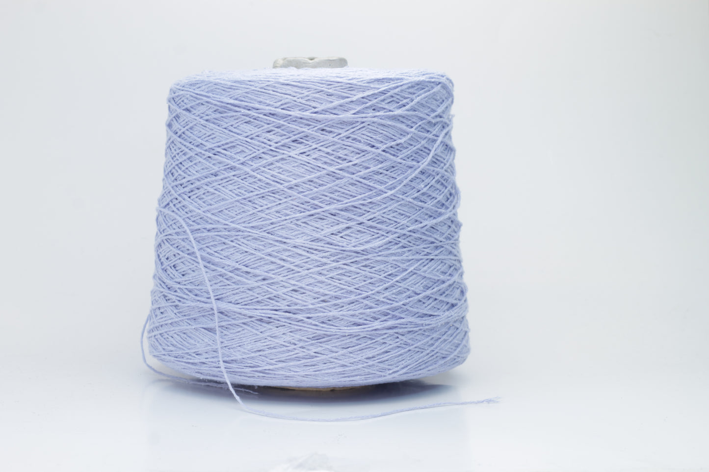 Close-up of a skein of soft, nubby Serenity blue bourette silk yarn. Its matte finish and subtle slubs reveal a raw, natural texture.