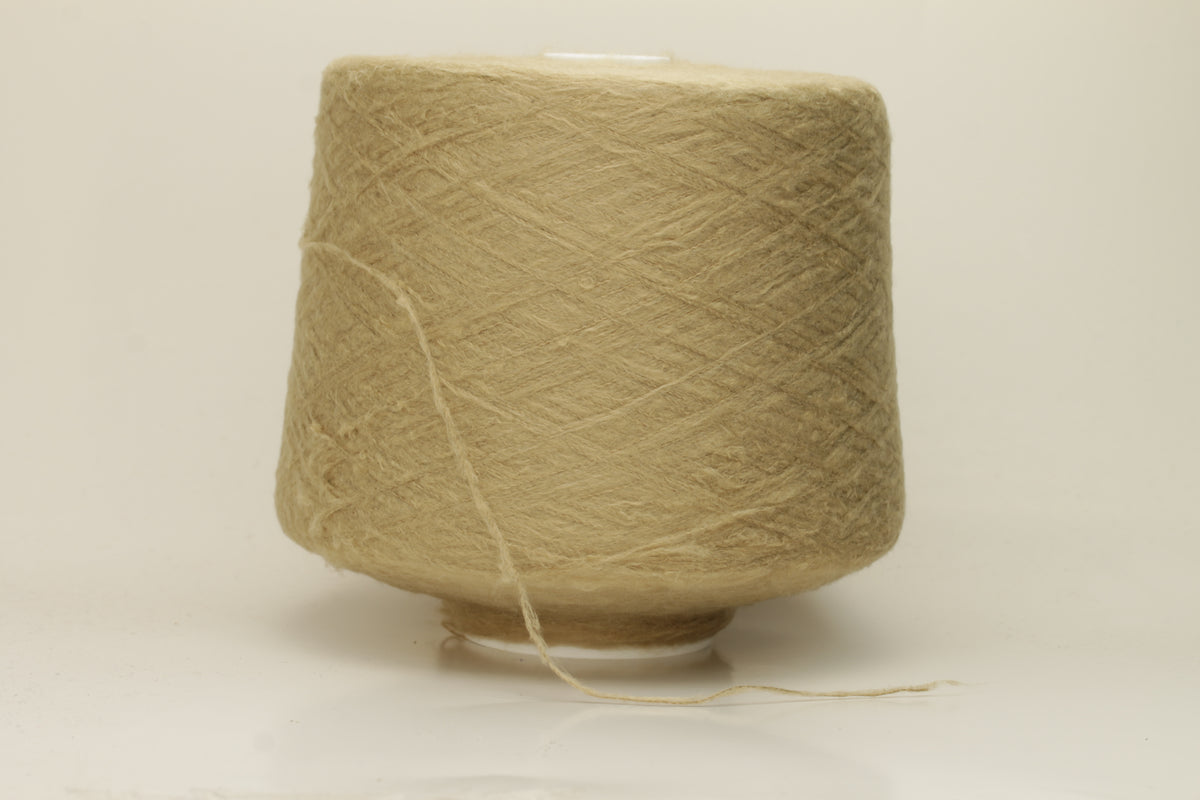 Luxurious, pristine Beige single-ply silk yarn with a smooth, uniform texture and a delicate sheen, softly coiled.