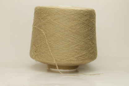 Luxurious, pristine Beige single-ply silk yarn with a smooth, uniform texture and a delicate sheen, softly coiled.