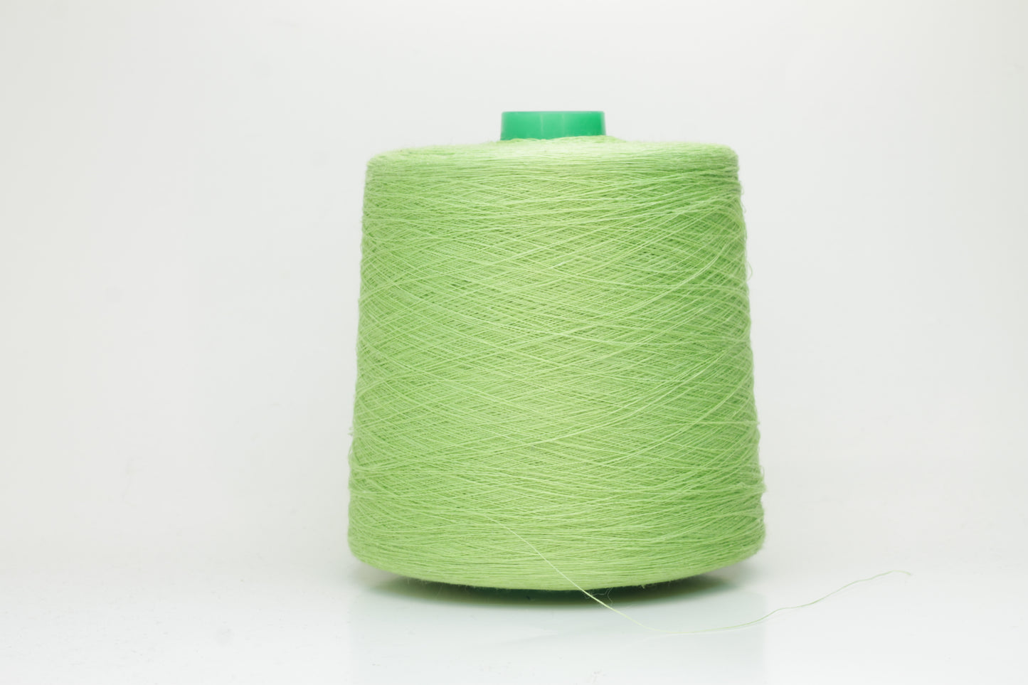 Fine, single-ply linen yarn in a rich Light Apple Green. Reveals a crisp texture and subtle natural sheen, typical of pure linen fiber.