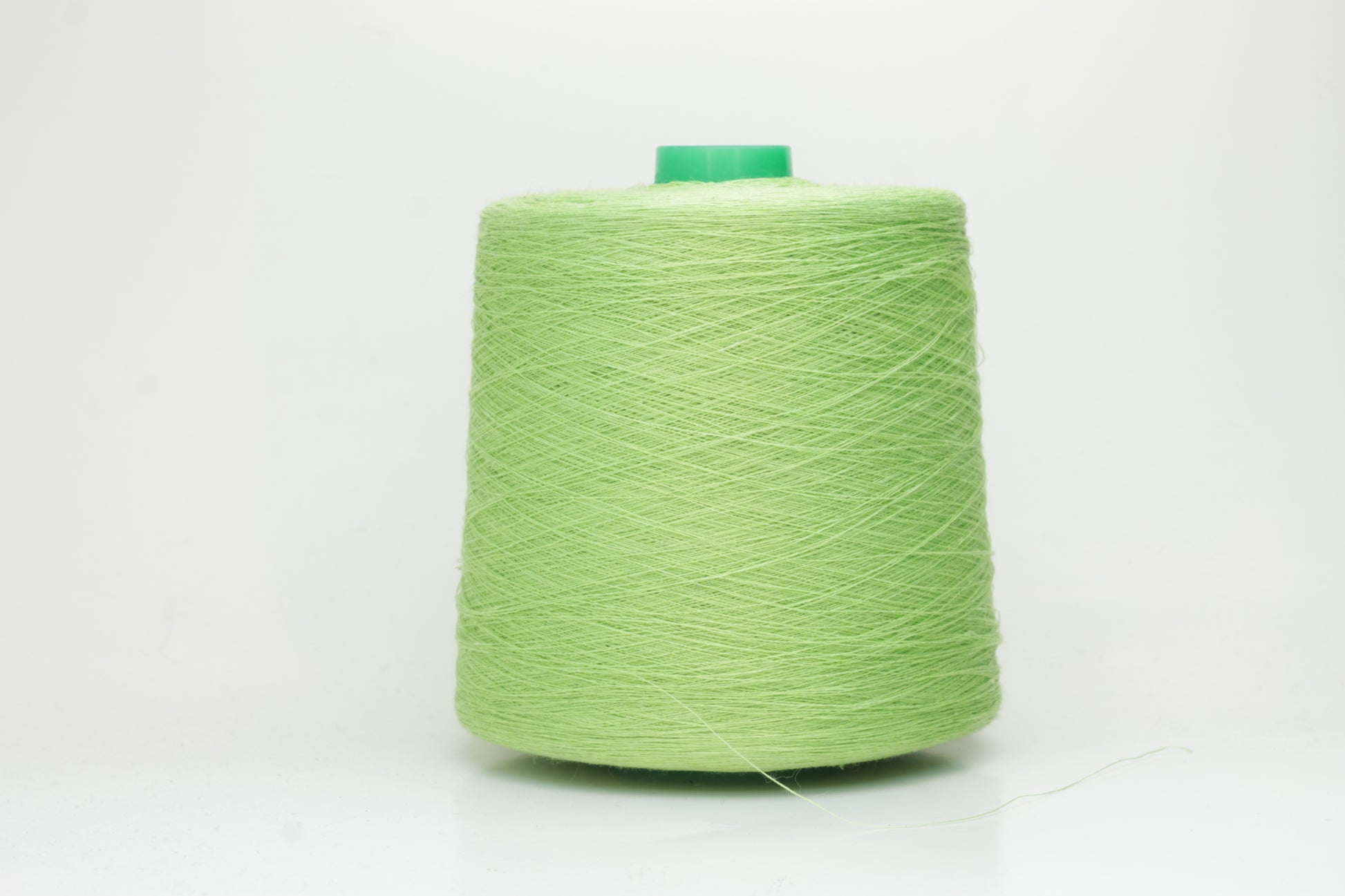 Fine, single-ply linen yarn in a rich Light Apple Green. Reveals a crisp texture and subtle natural sheen, typical of pure linen fiber.