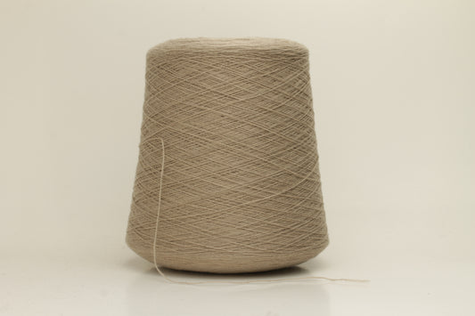 Close-up of a skein of incredibly soft, two-ply cashmere yarn in a deep, warm Mastice beige. Fine fibers with a subtle halo and elegant twist visible.