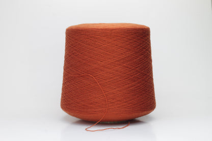 Close-up of luxurious Terra Cotta Merino wool yarn, two-ply twist with a soft, subtle sheen, and fine, consistent thread structure.