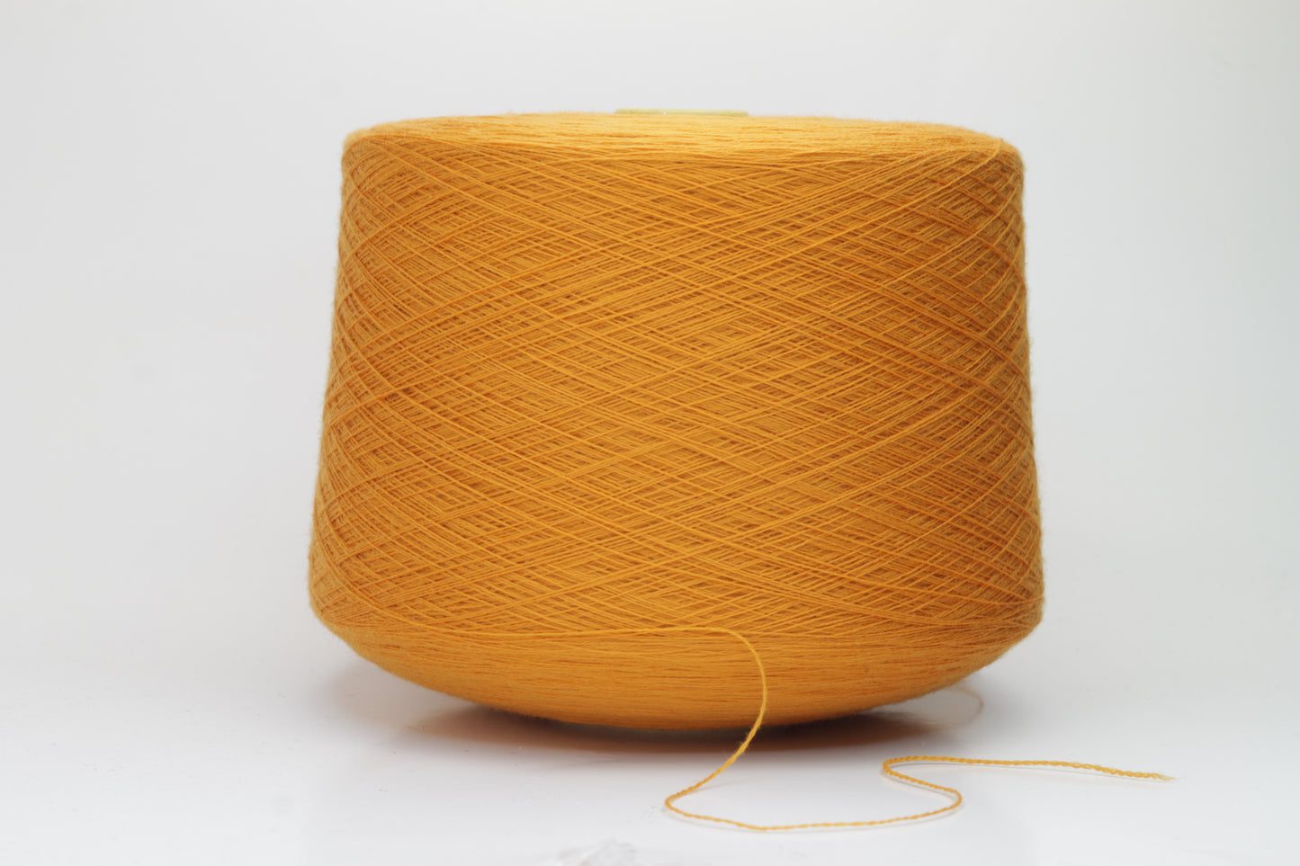 Close-up view of a vibrant orange Zegna Baruffa Merino yarn skein, showcasing the dense ply twist and smooth, fluffy texture with subtle sheen reflecting light.