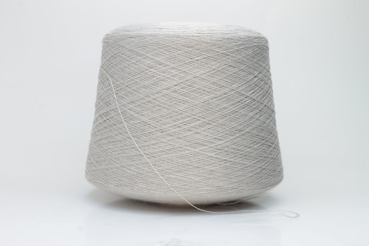 Close-up shot of a vibrant, creamy beige merino yarn skein, showcasing its subtle sheen, delicate ply twist, and the fine, soft texture of the fibers.