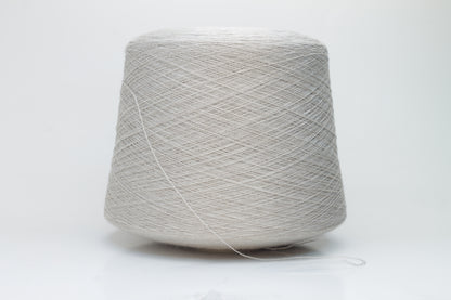 Close-up shot of a vibrant, creamy beige merino yarn skein, showcasing its subtle sheen, delicate ply twist, and the fine, soft texture of the fibers.