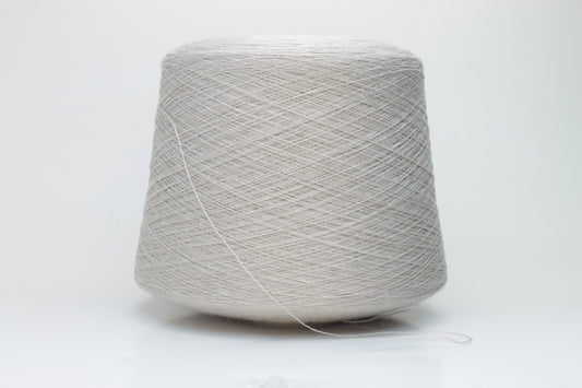 Close-up shot of a vibrant, creamy beige merino yarn skein, showcasing its subtle sheen, delicate ply twist, and the fine, soft texture of the fibers.