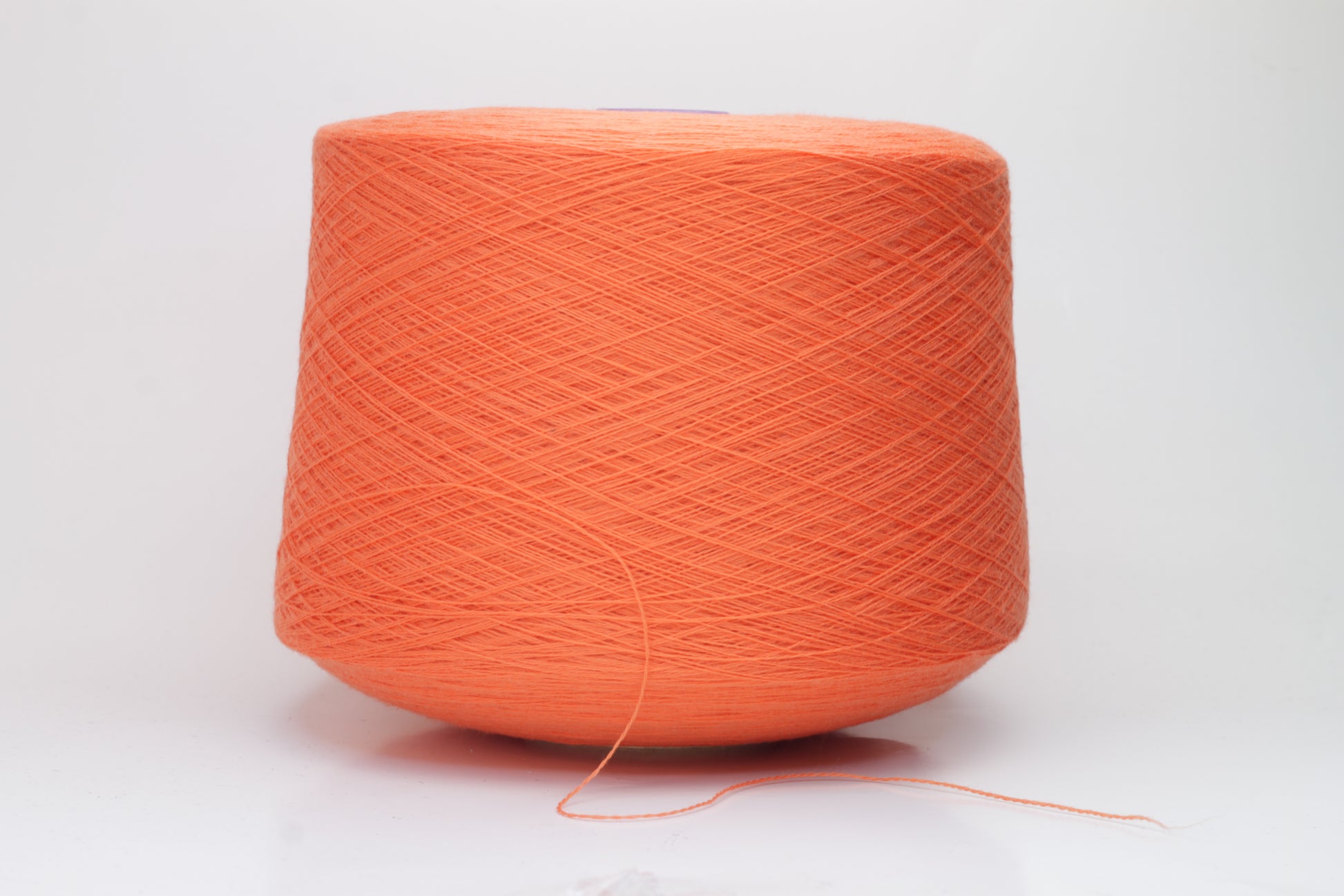 Close-up view of vibrant orange Merino 100% Cashwool yarn, showcasing a tight ply twist and a dense, fluffy texture with subtle sheen.