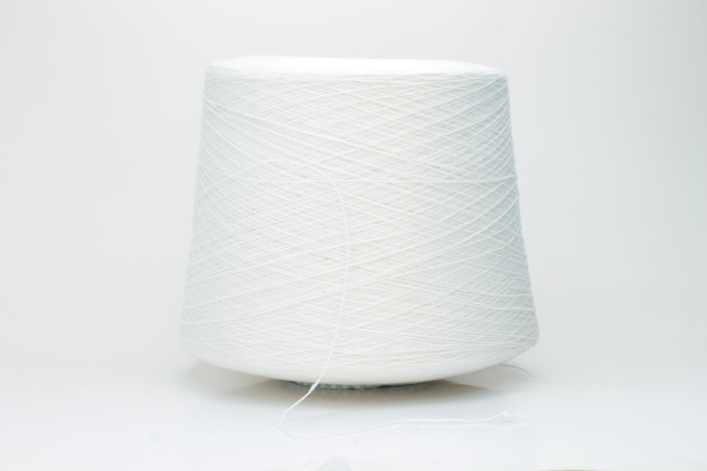 Close-up of a luxurious, soft skein of pale, milky blue cashmere yarn with a subtle sheen and light, even two-ply twist.