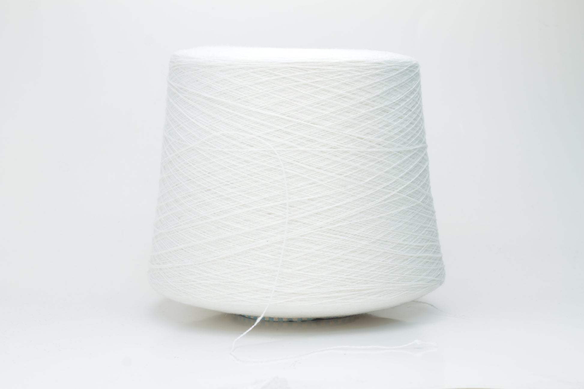 Close-up of a luxurious, soft skein of pale, milky blue cashmere yarn with a subtle sheen and light, even two-ply twist.