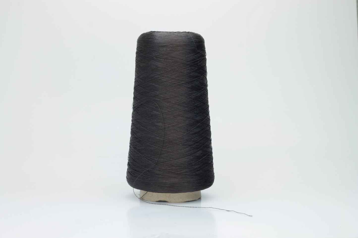 Coiled skein of single-ply, fine gauge silk yarn in a soft, bright sky blue. It exhibits a subtle, natural sheen with a smooth texture.